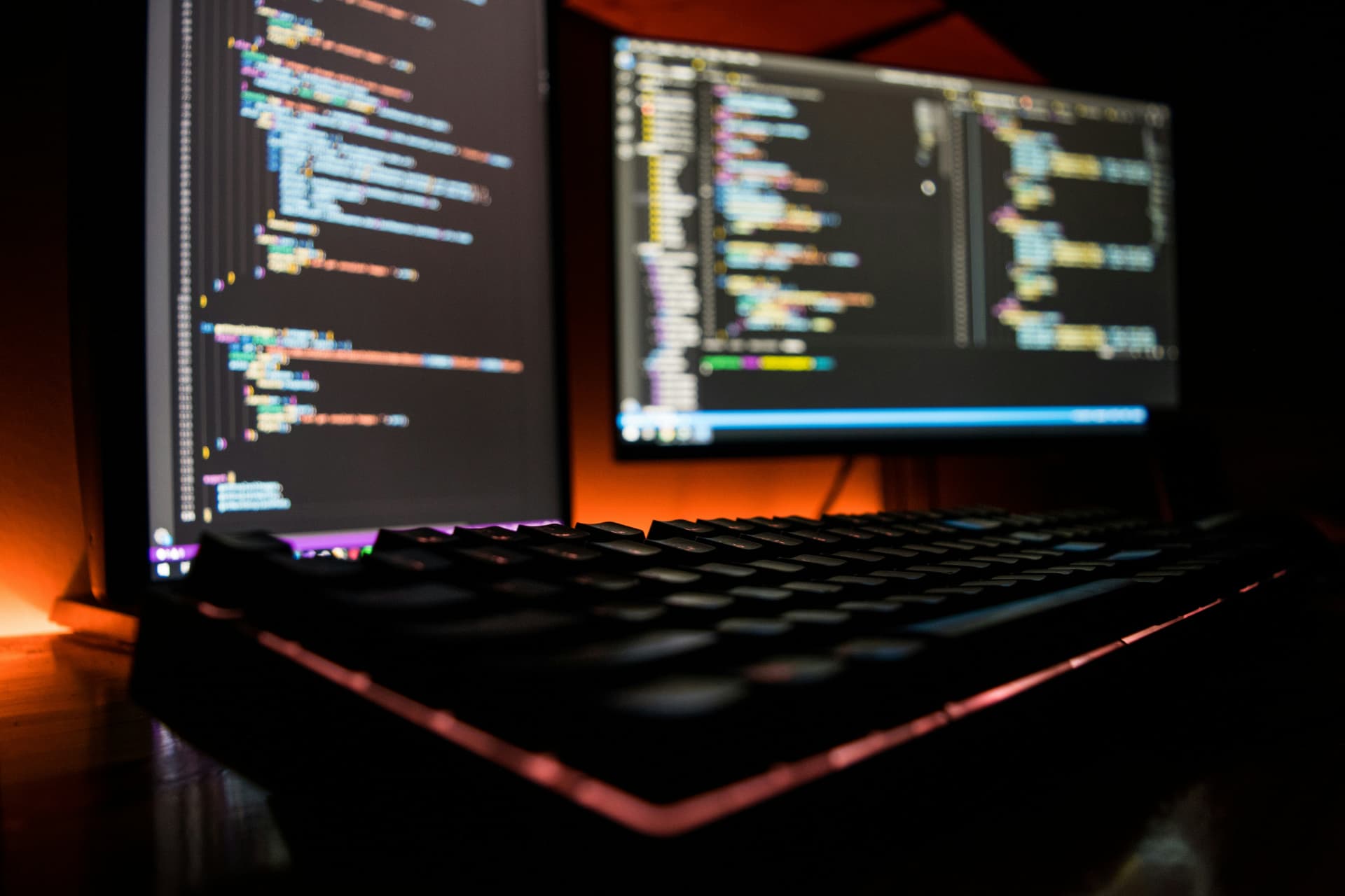 Dual monitors showing live code with a mechanical keyboard in a focused development environment